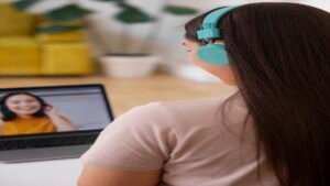 Participante de curso online assistindo a aula em vídeo com fones de ouvido em ambiente doméstico